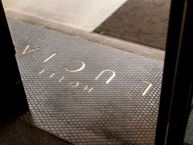 This image shows the entrance of a hotel with hexagonal tile flooring and the word 